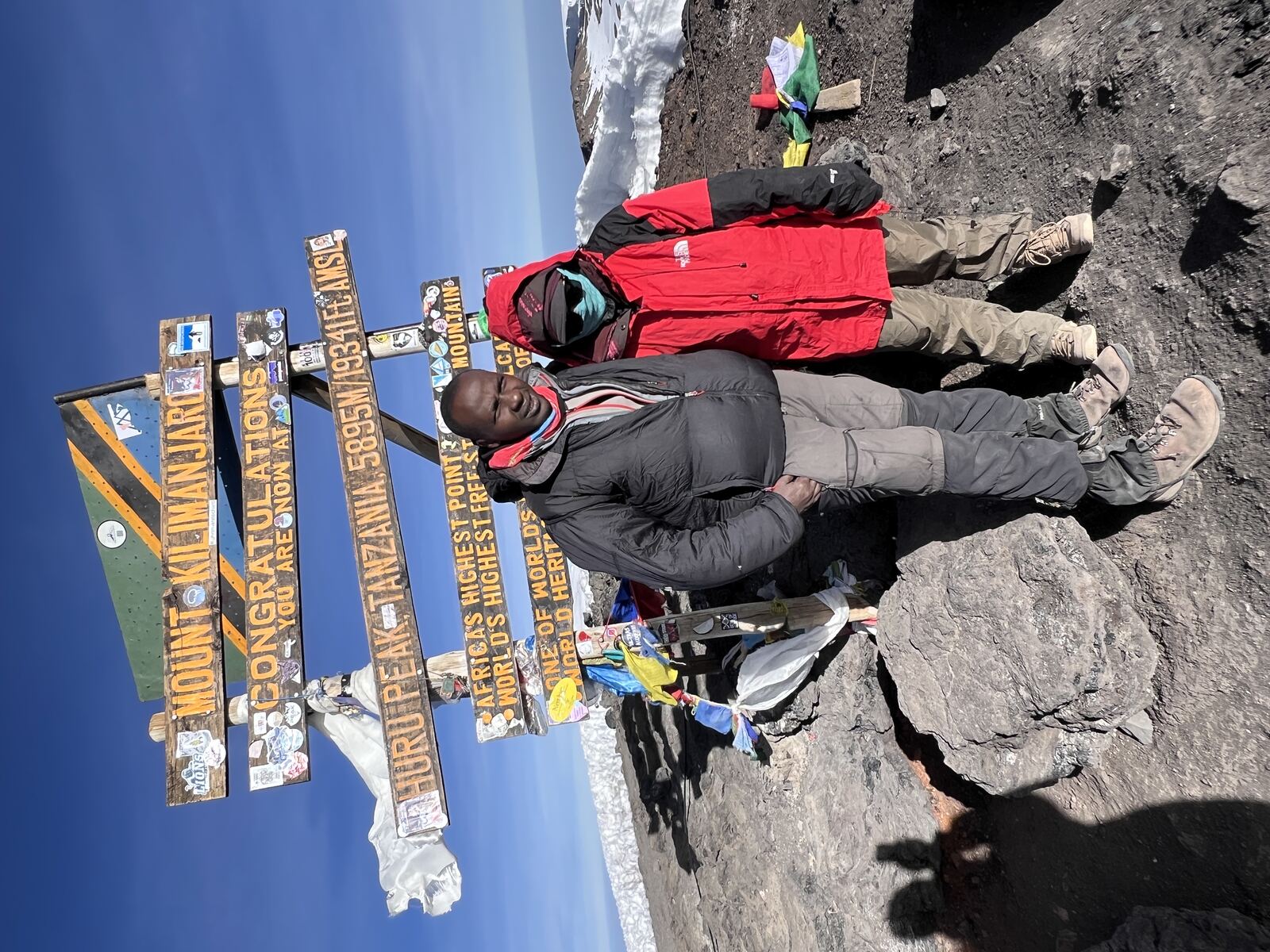 與嚮導在 Uhuru Peak 標示牌前合照